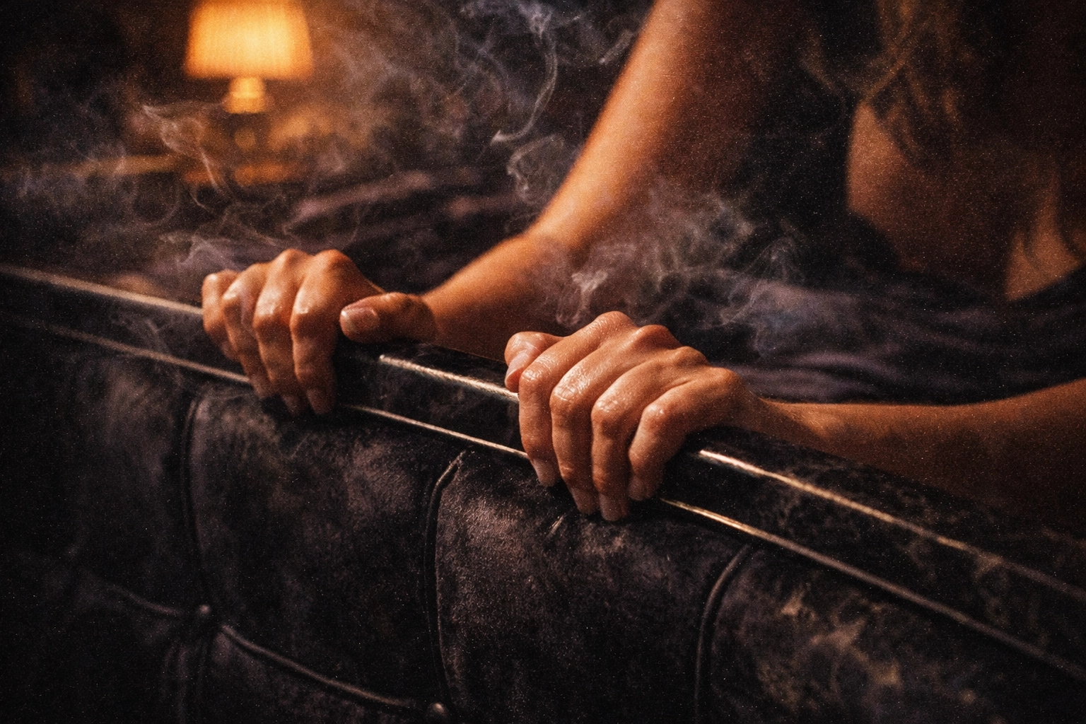 Hands gripping bedframe showing anticipation and vulnerability in BDSM scene