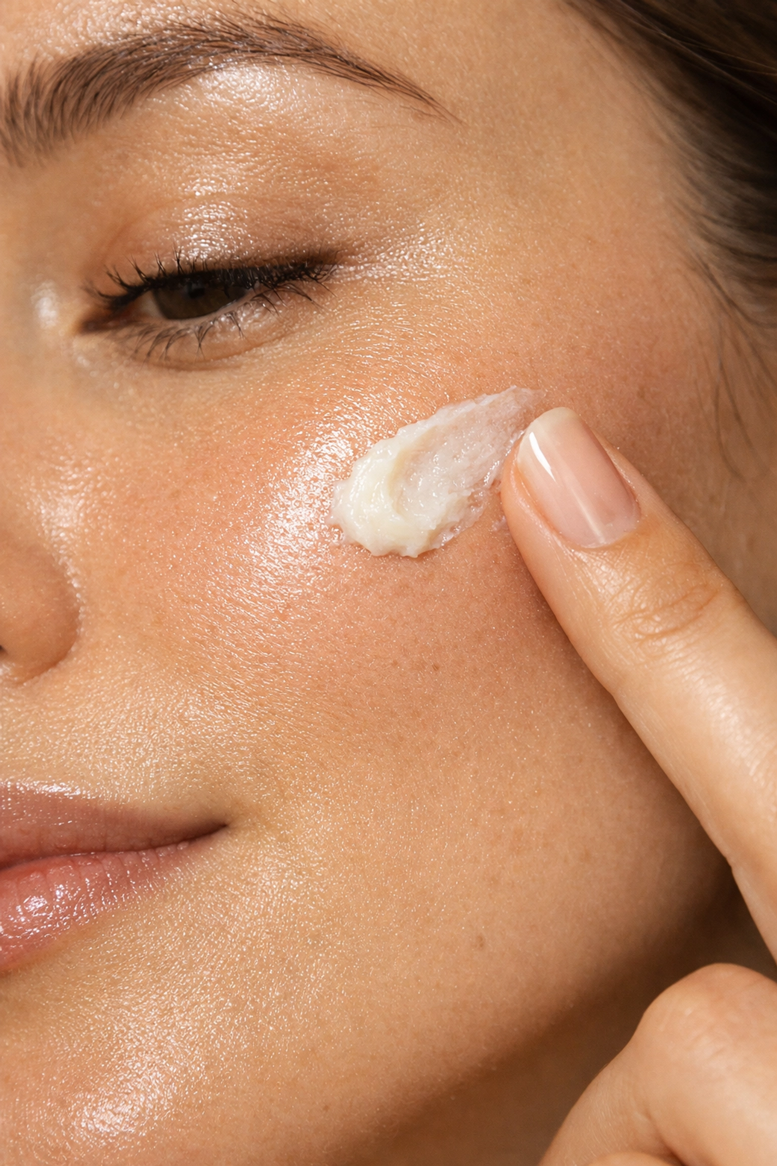 Applying tallow and honey balm to a glowing cheek to support the natural skin barrier.