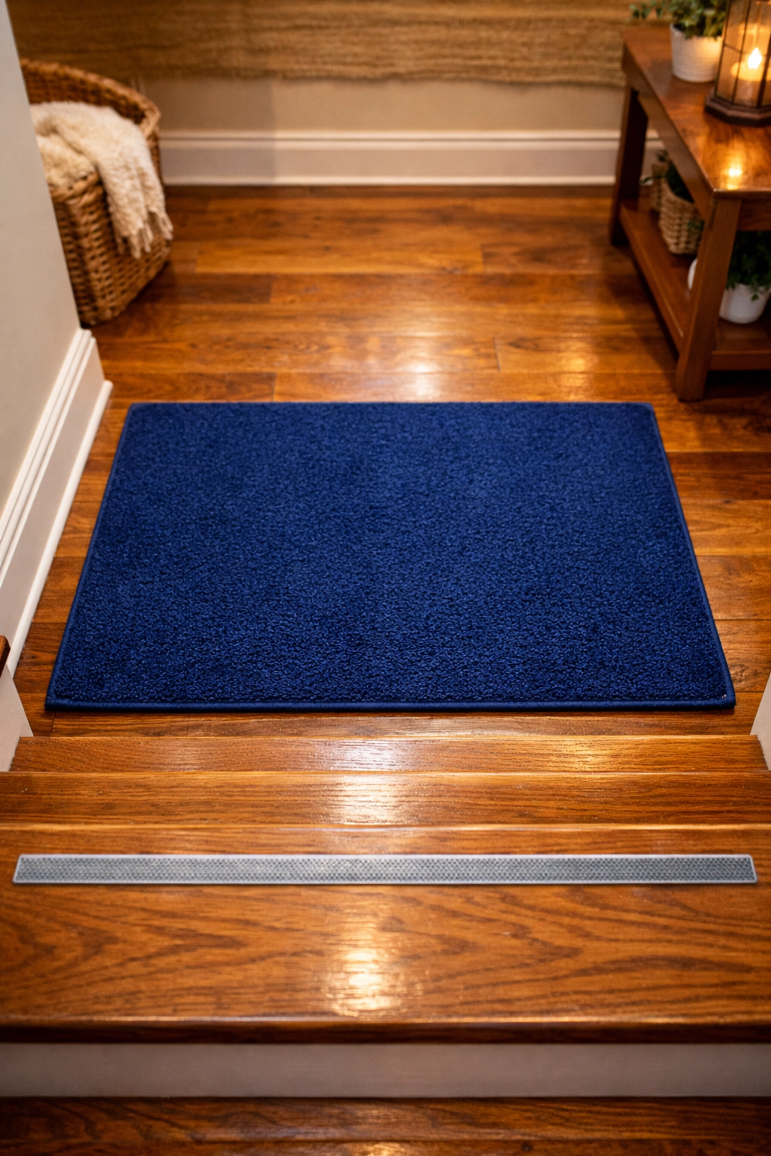 High-contrast non-slip rug at the base of stairs to prevent the bottom-of-flight illusion.