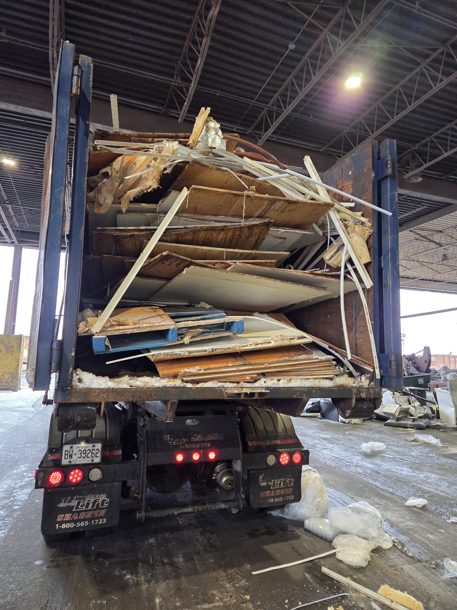 Managing Heavy Construction Debris: 4-Yard vs 10-Yard Bins in North York A loaded roll-off bin is tilted on a truck, dumping construction debris at a waste transfer station.