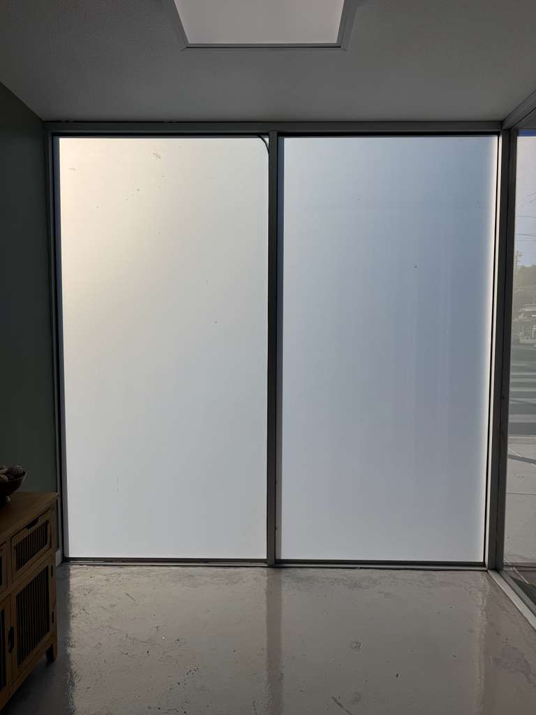 Two large glass panels retrofitted with Smart View’s switchable film are shown in frosted mode, providing privacy and diffusing sunlight.