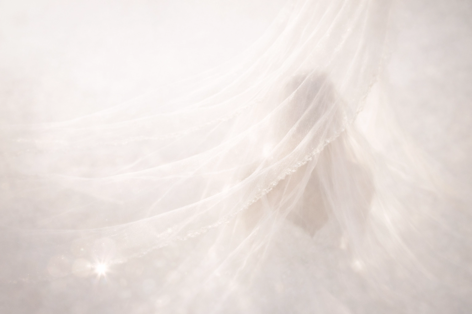 Mysterious and soft image of a bridal veil catching golden light, radiating wedding day joy.