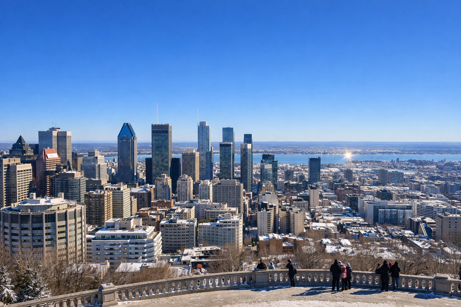 Panoramic view of the Montreal skyline from Mount Royal under a clear, bright blue sky.