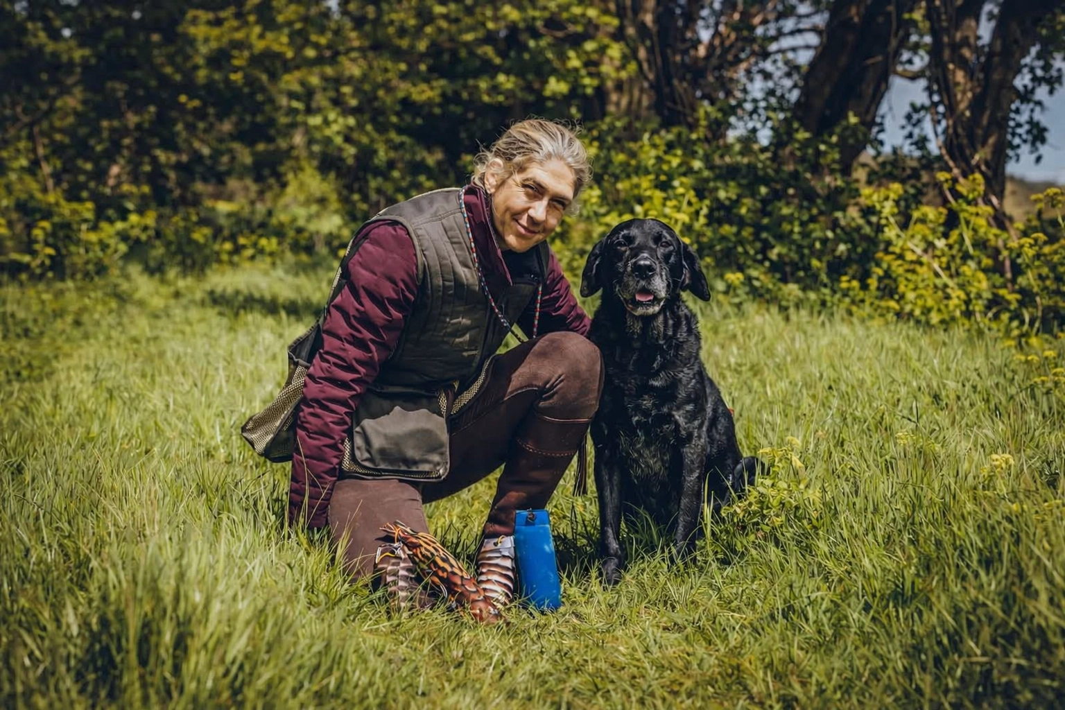gundog-trainer-black-labrador-training-grassy-field.webp