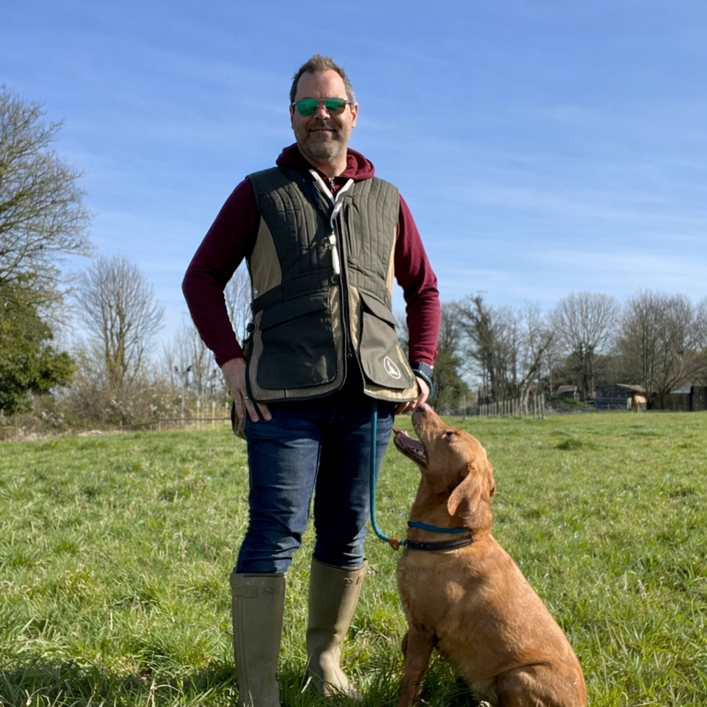 gundog-trainer-with-dog-in-field.webp