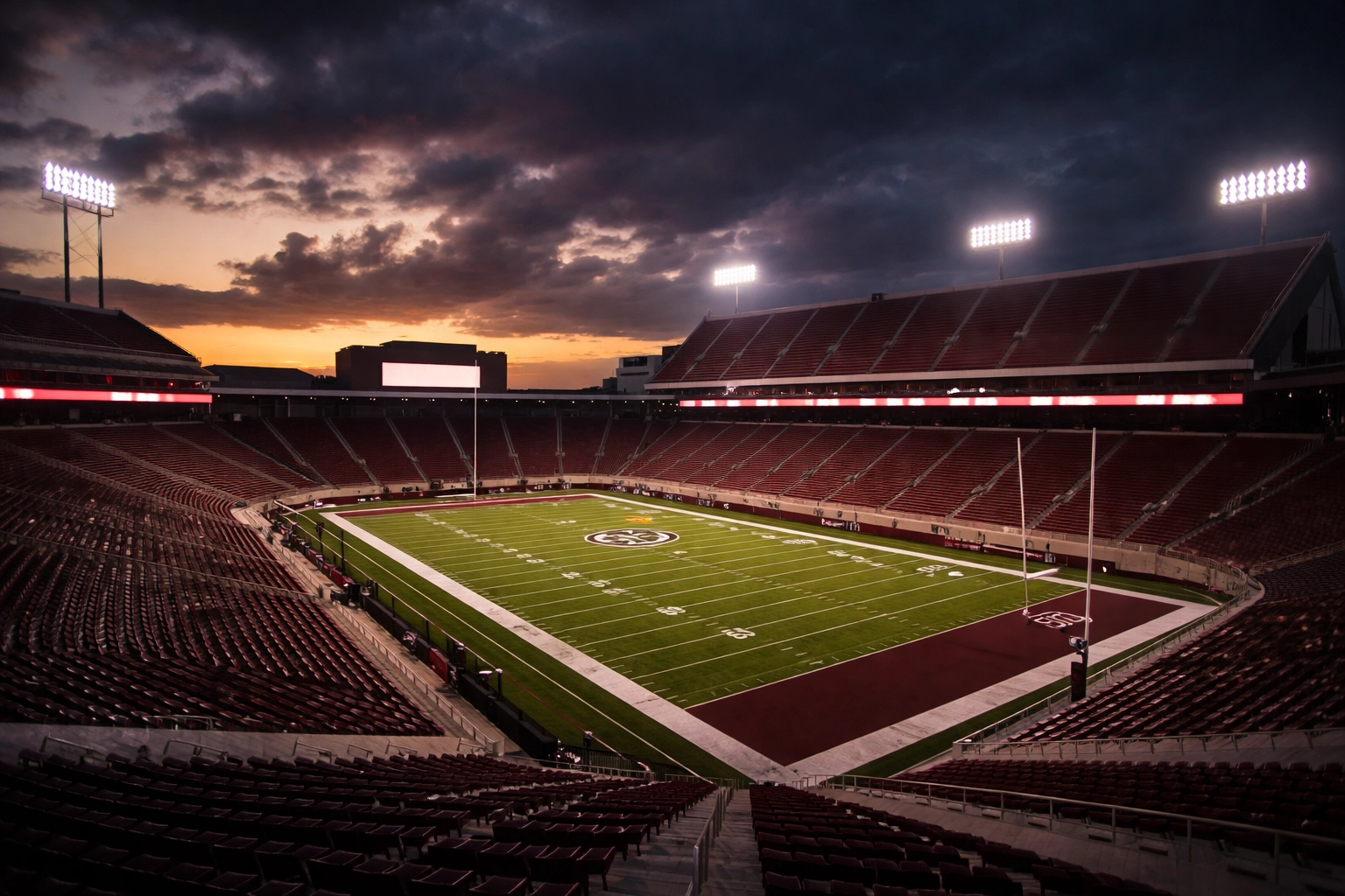Empty Mississippi State football stadium at dusk showcases anticipation and maroon and white school spirit.