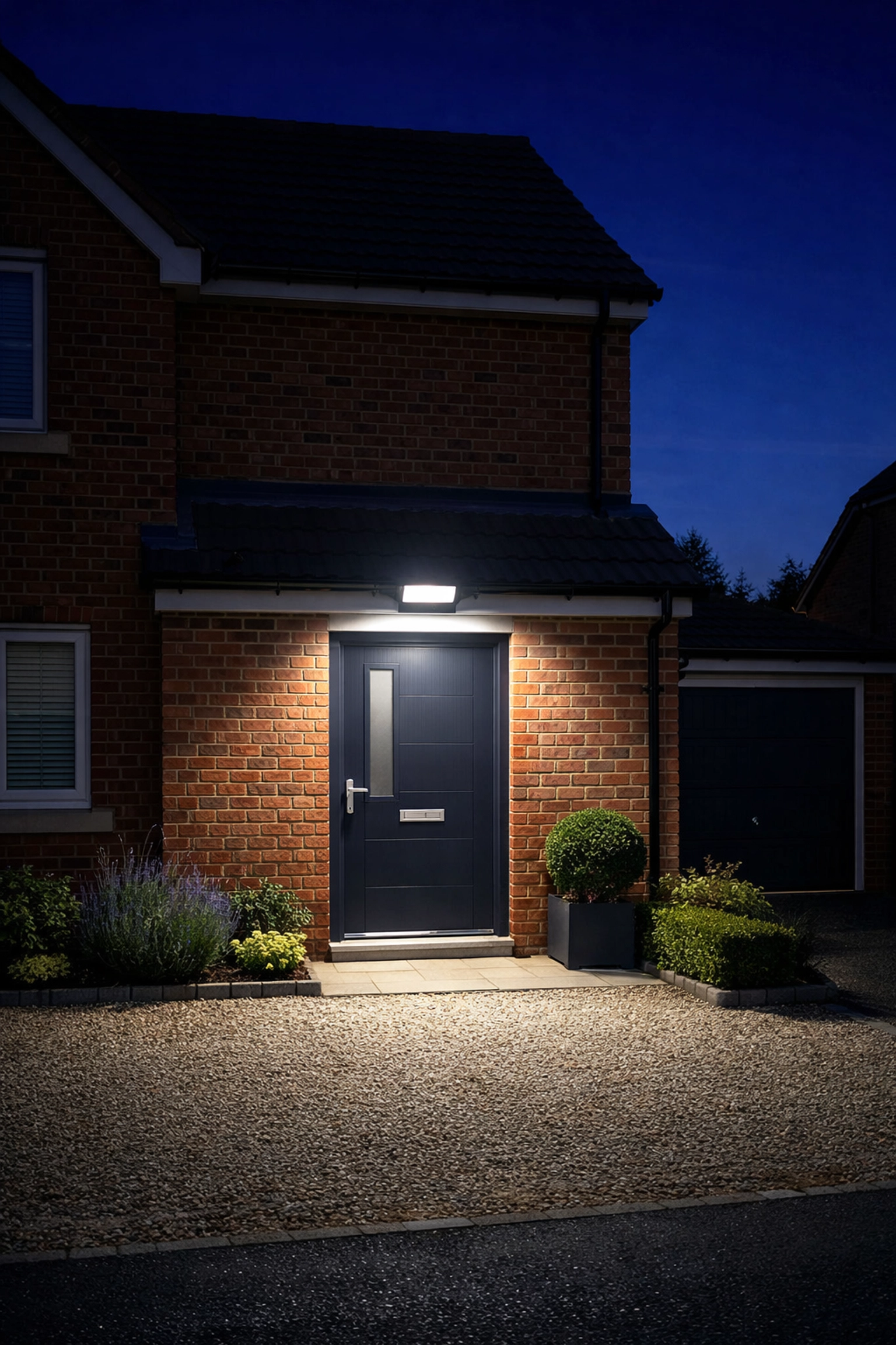 Modern LED outdoor security floodlight with motion sensors on a residential home in Dorset.