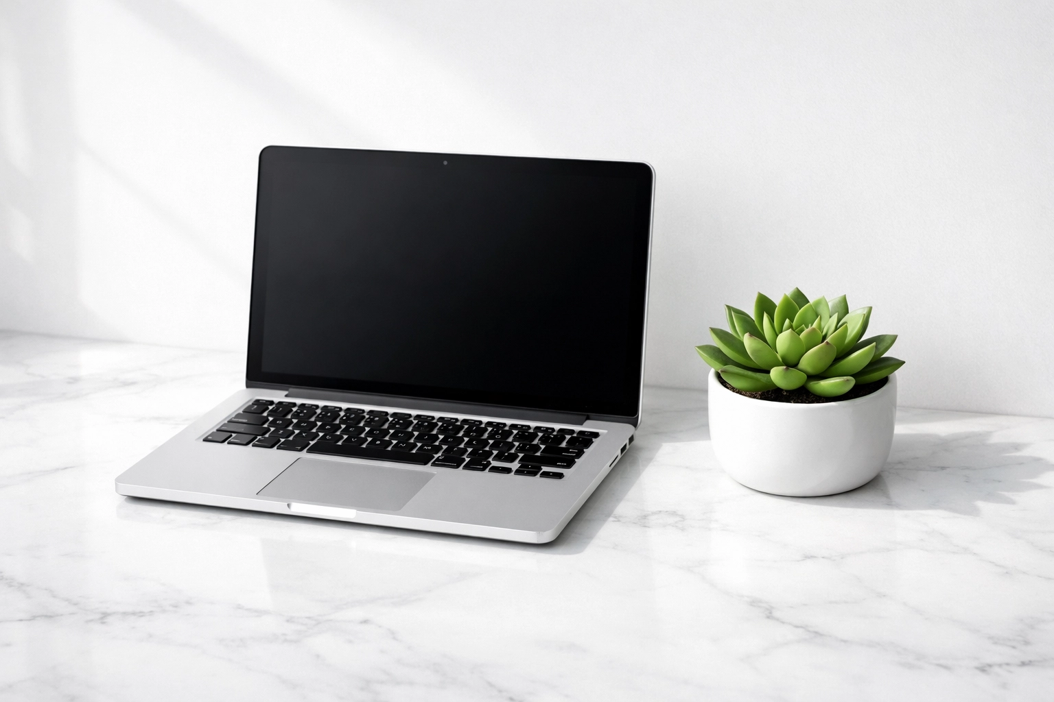Minimalist workspace with a laptop representing a professional managed website service.