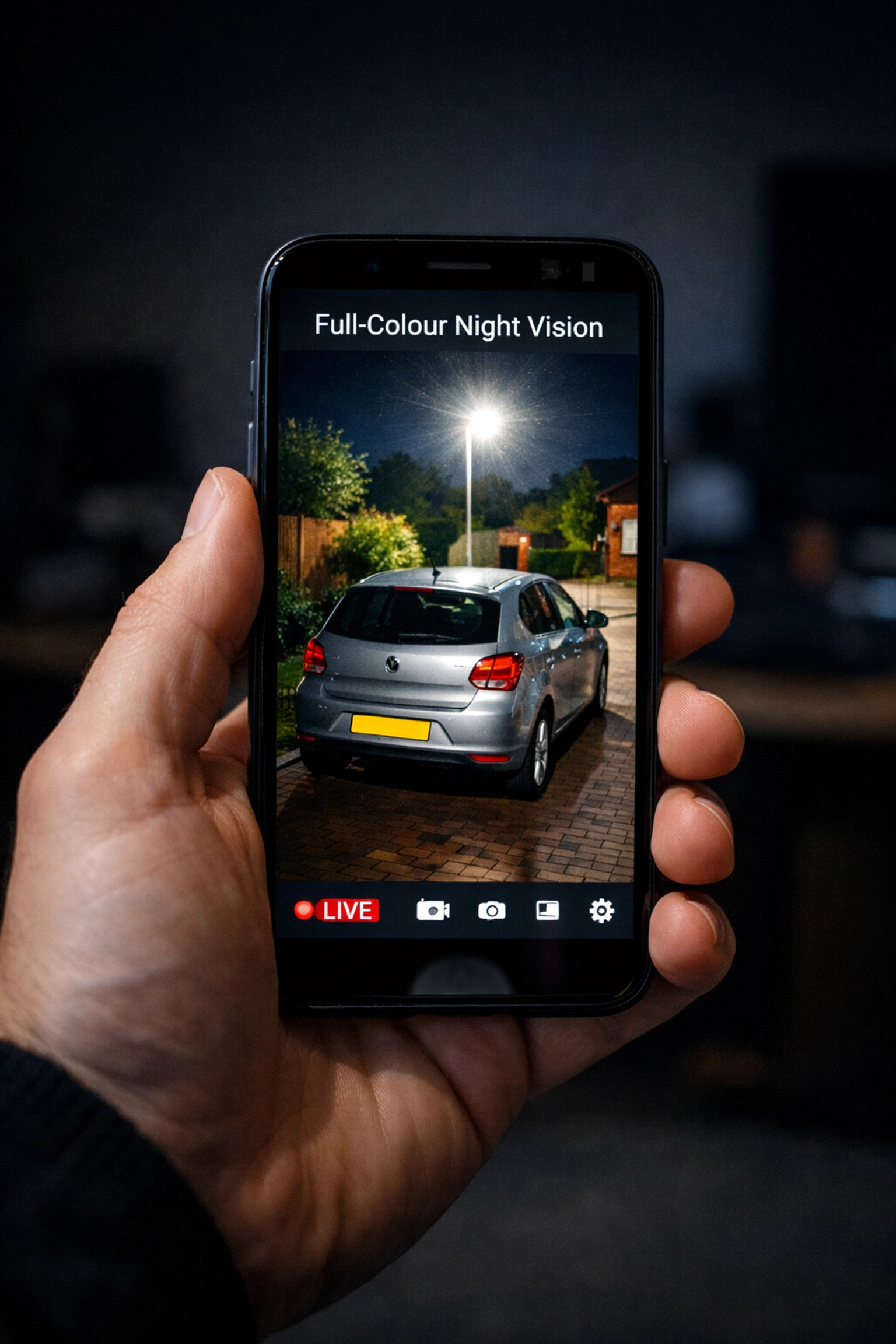 Smartphone app showing a full-colour night vision CCTV camera feed of a car parked on a Swindon driveway.