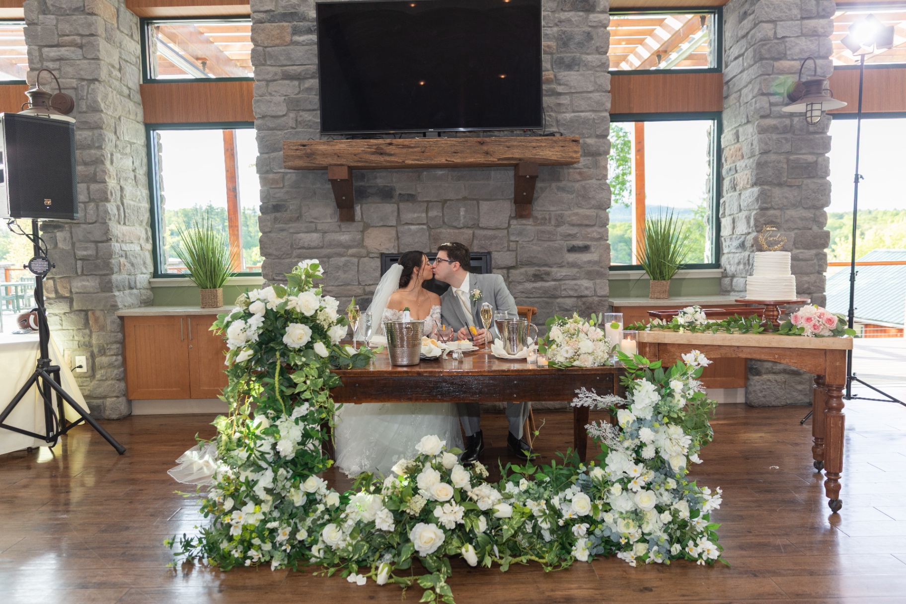 Bride and groom share a kiss at the sweetheart table