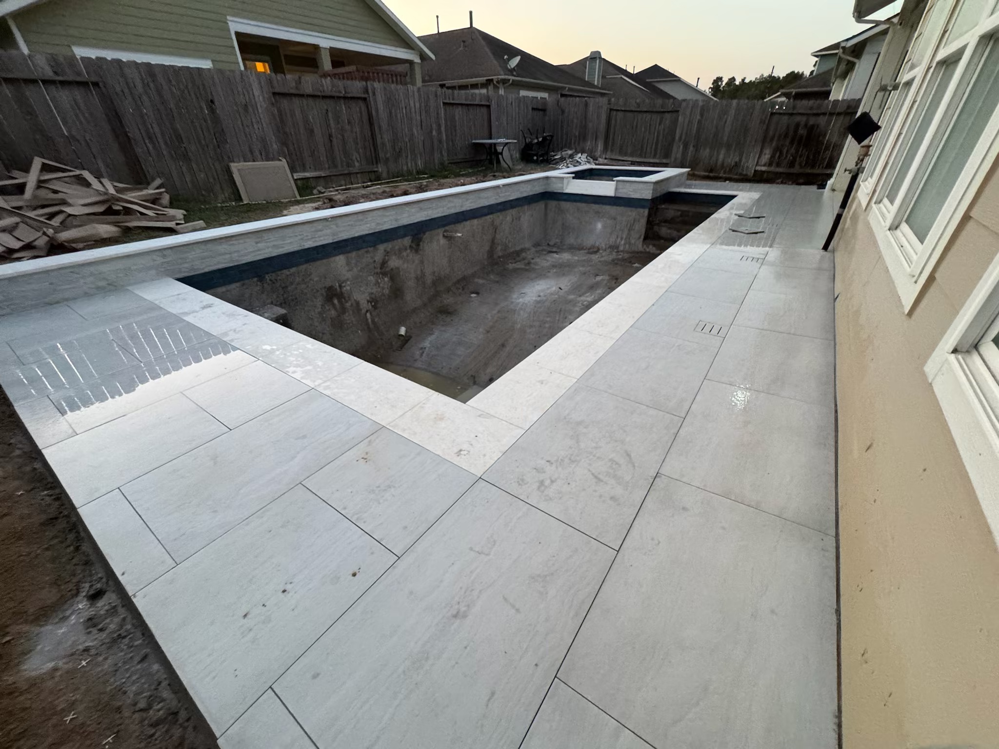 Completed luxury backyard pool at sunset in The Woodlands, highlighting a finished swimming pool project