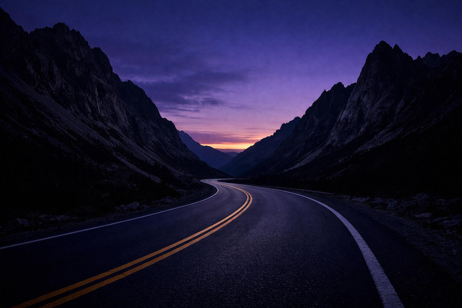 A winding road through dark mountain peaks at twilight representing the start of a transformative travel journey.