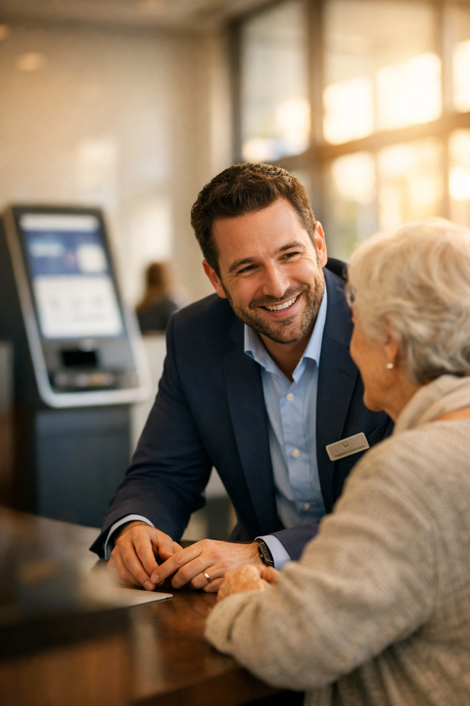 A bank employee providing personalized hospitality and human connection to a customer in a modern branch.