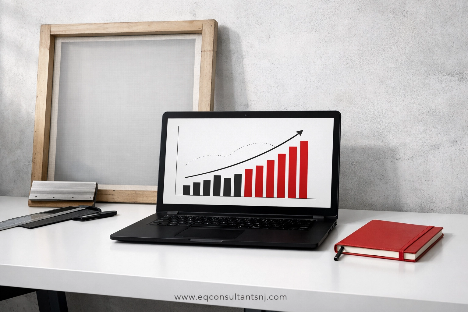 Professional workspace showing financial charts on a laptop using QuickBooks for screen printers to track growth.