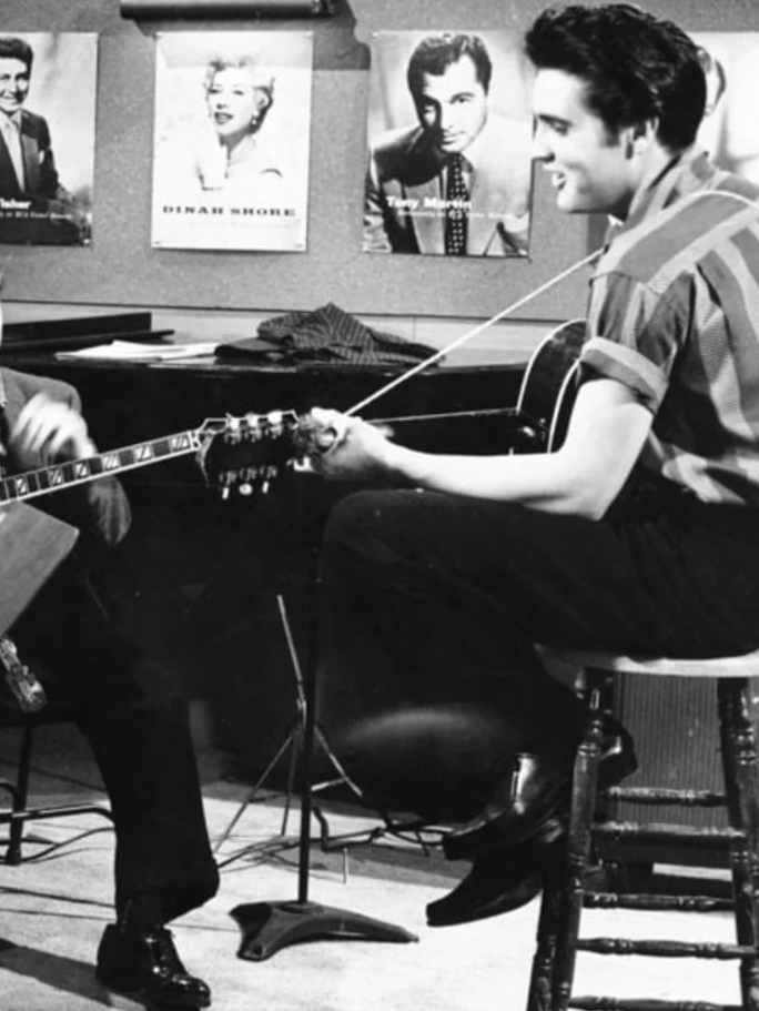 Elvis Presley playing guitar in a studio setting