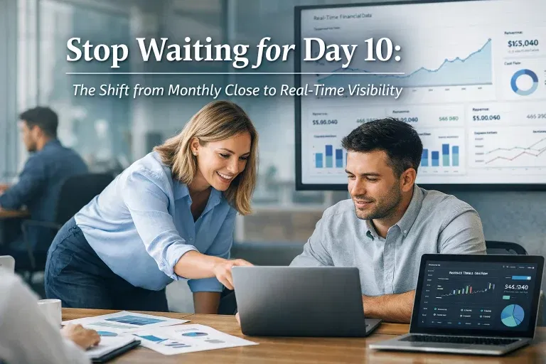 Two consultants review real-time financial dashboards on laptops in a modern office