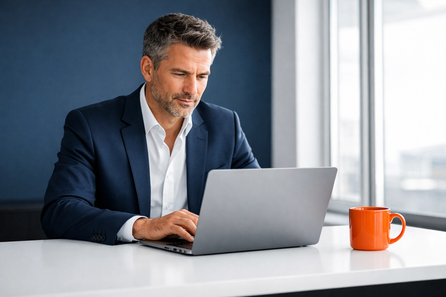 A focused business owner in a modern office reviewing secure financial data to protect his business valuation.