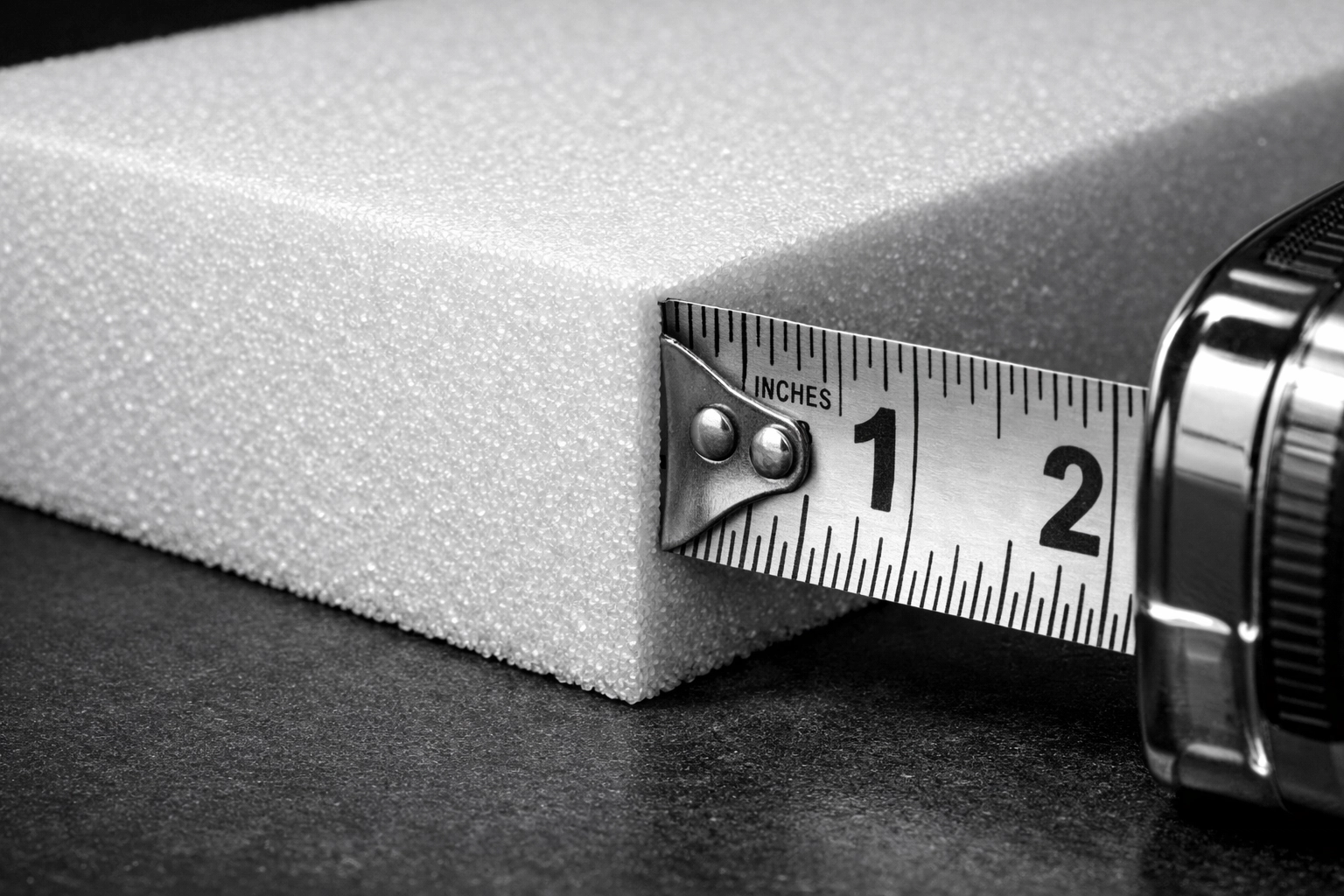Measuring high-density foam thickness for precision custom cushion fabrication at Stuff It Upholstery.