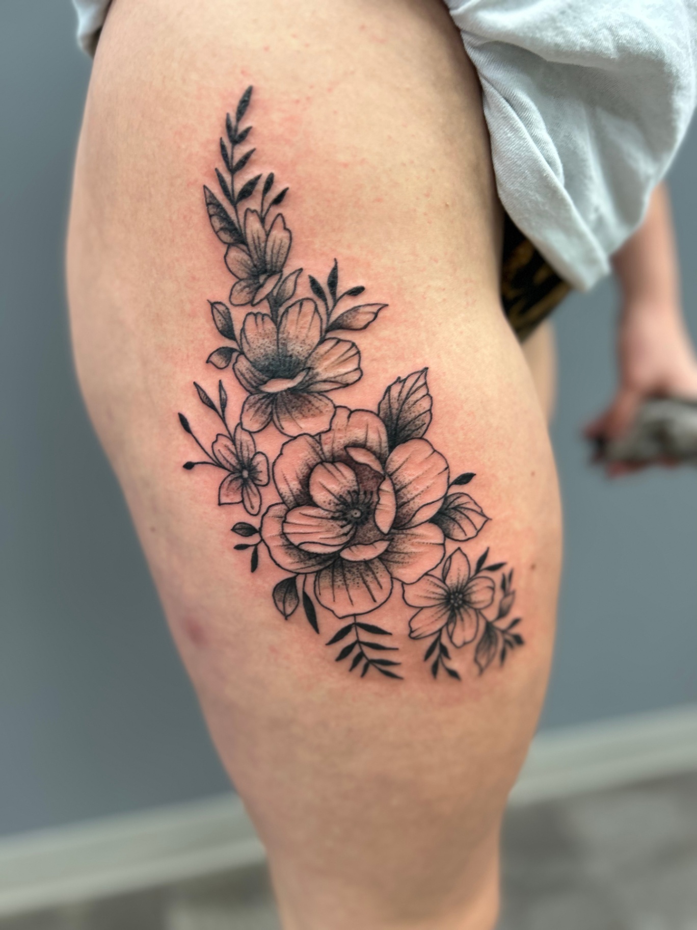 Black and grey floral thigh tattoo