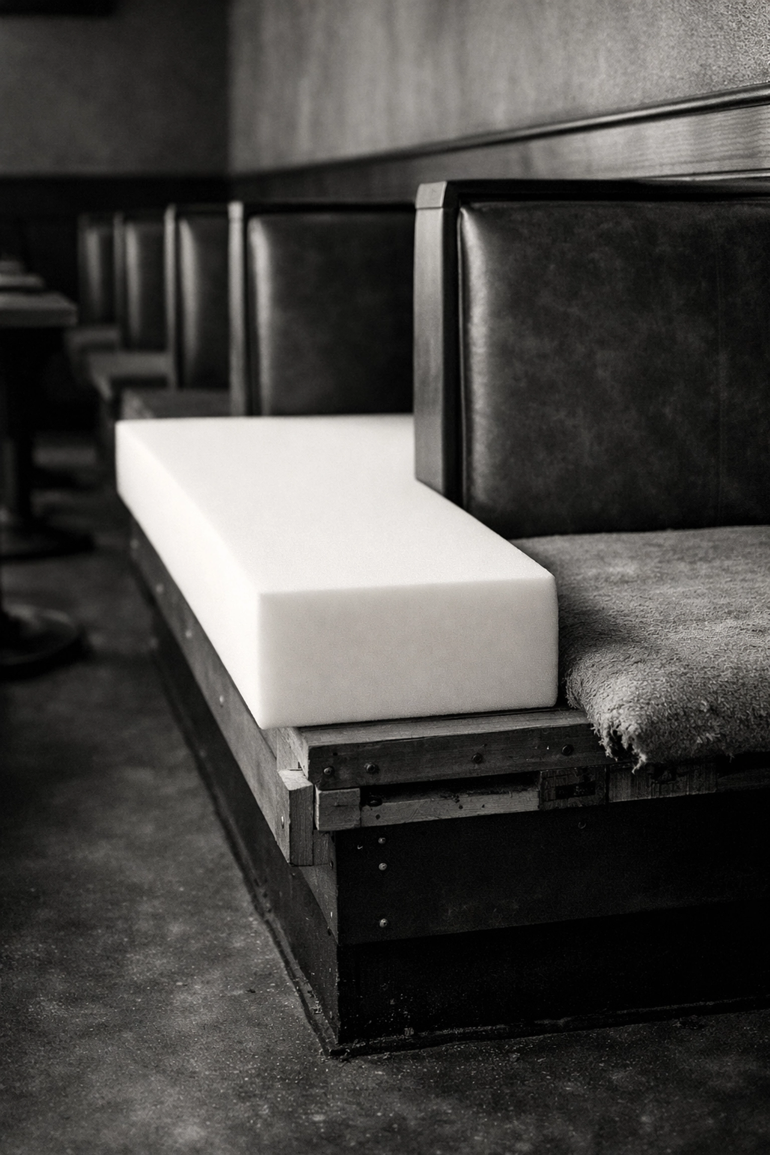 High-density foam being installed in a commercial restaurant booth for improved durability.