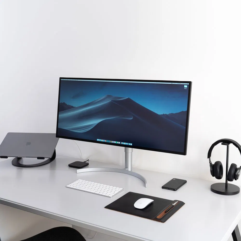 Sleek modern desktop setup featuring an ultrawide monitor and laptop stand