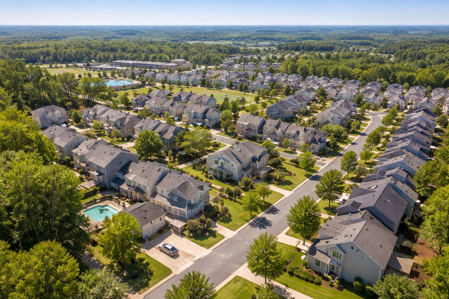 Photorealistic aerial drone view of a growing suburban neighborhood with tree-lined streets and single-family homes, representing market research for real estate investing