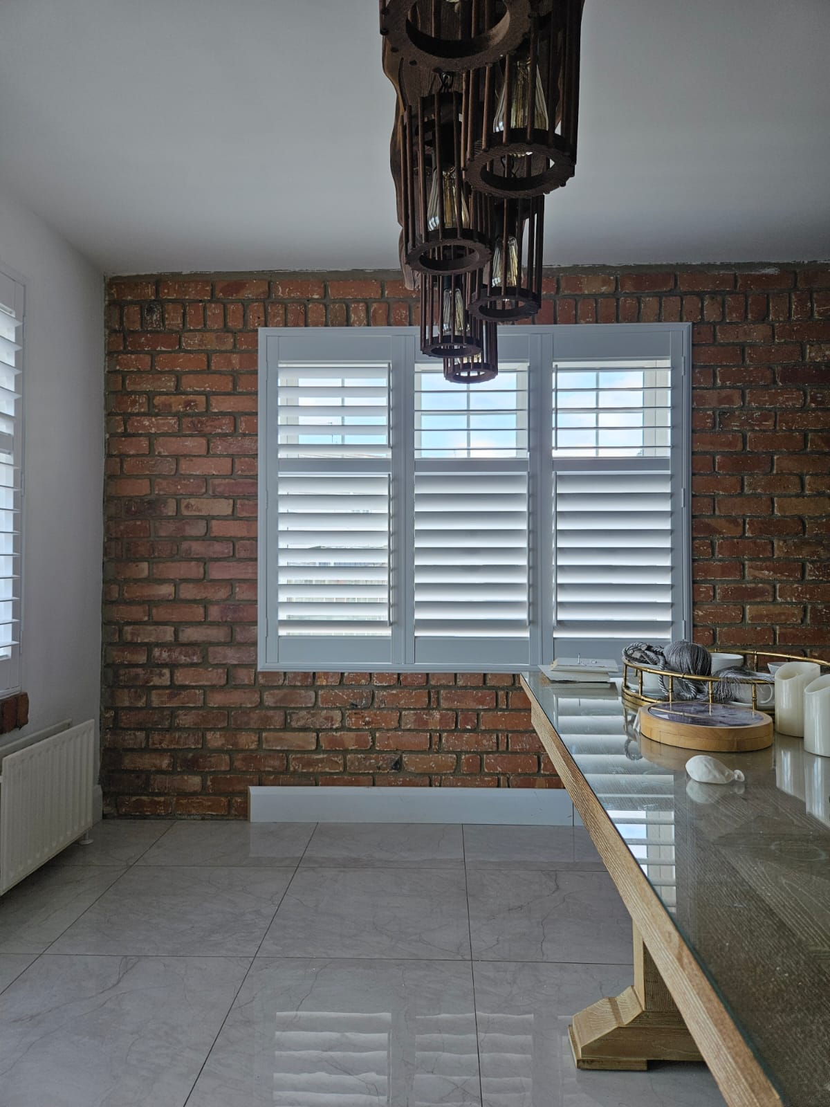 White plantation shutters professionally installed in a modern kitchen
