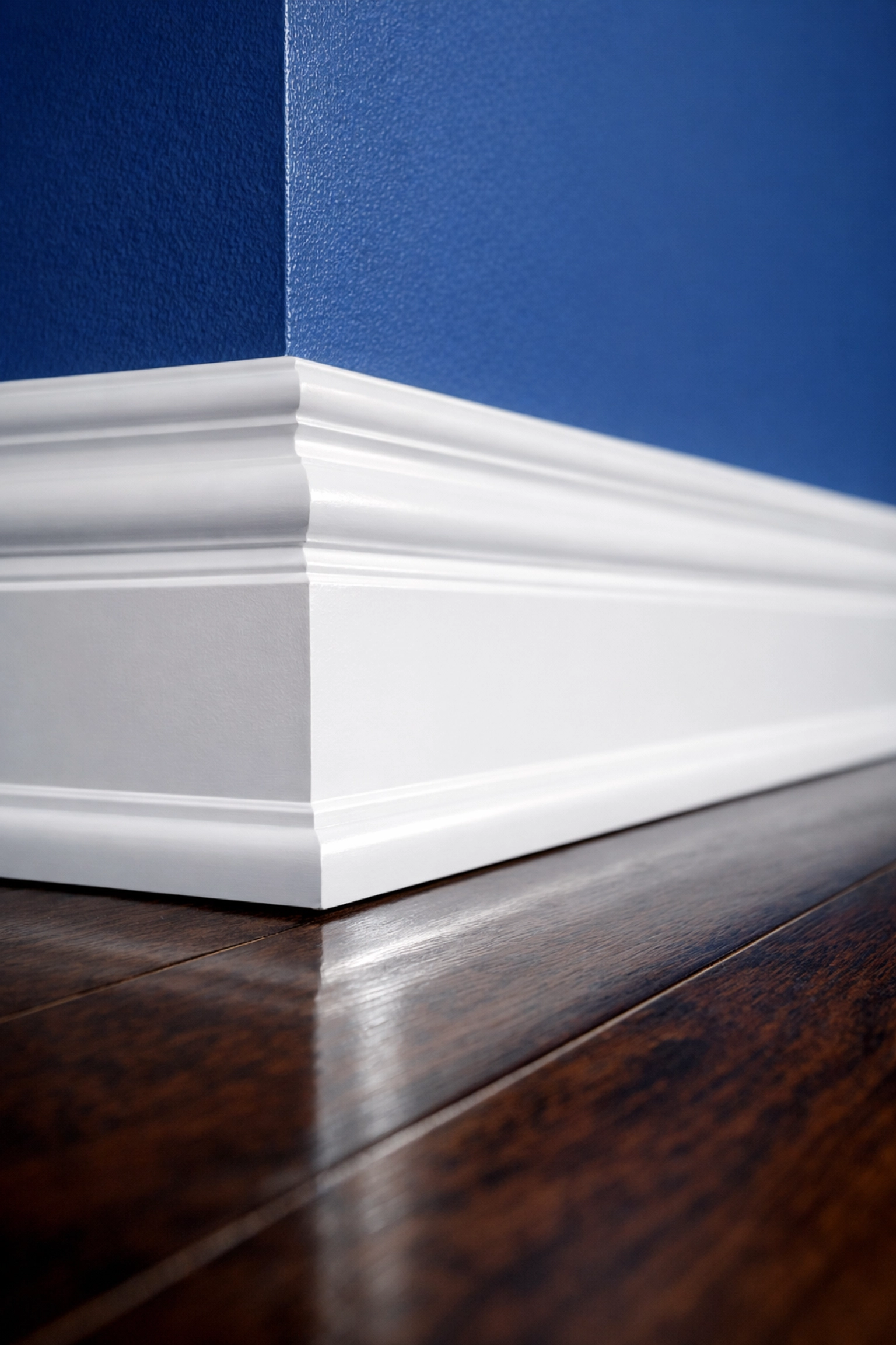 Close-up of dust-free white baseboards and polished hardwood floors from a deep cleaning Wellesley MA strike.