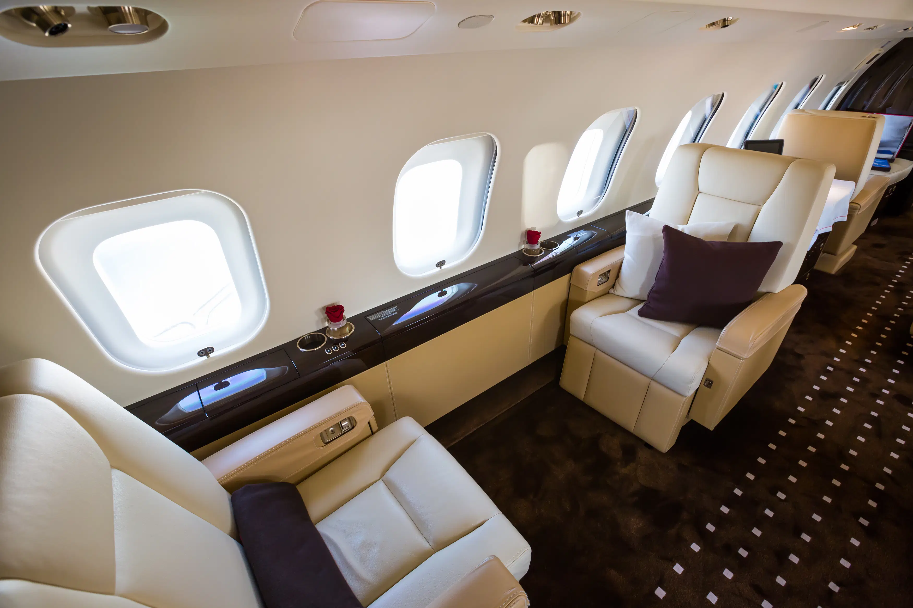Spacious private jet interior with plush cream leather seating (photo). Cabin finishes and exact configuration can vary by aircraft and operator.