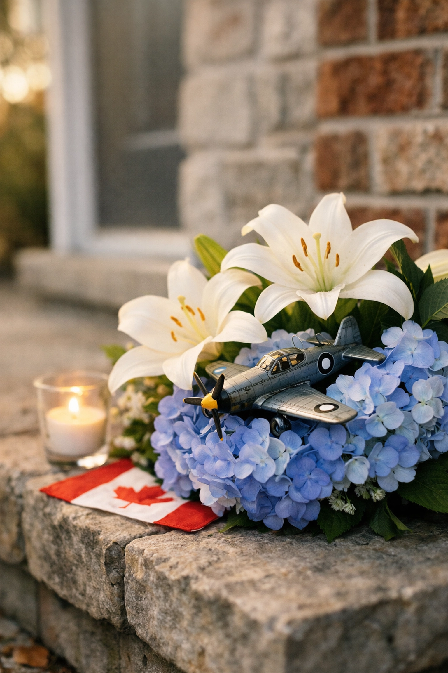 Flowers and a model airplane memorial on a Quebec doorstep for pilots Antoine Forest and Mackenzie Gunther.