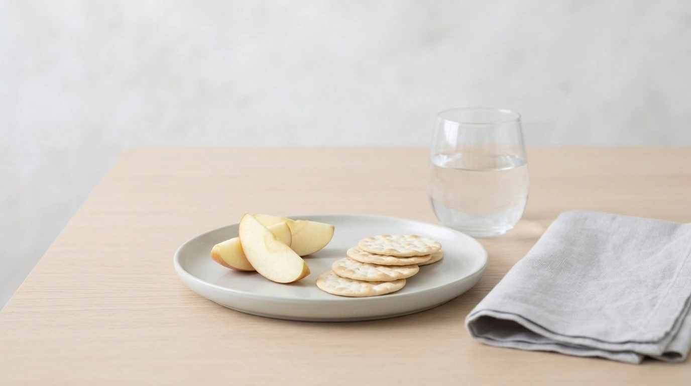 A close-up of a sensory-friendly, simple meal setting on a neutral wooden table.