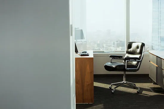 A modern, sunlit office with a sleek executive chair, symbolizing the professional, remote-friendly workspace of a modern finance broker.