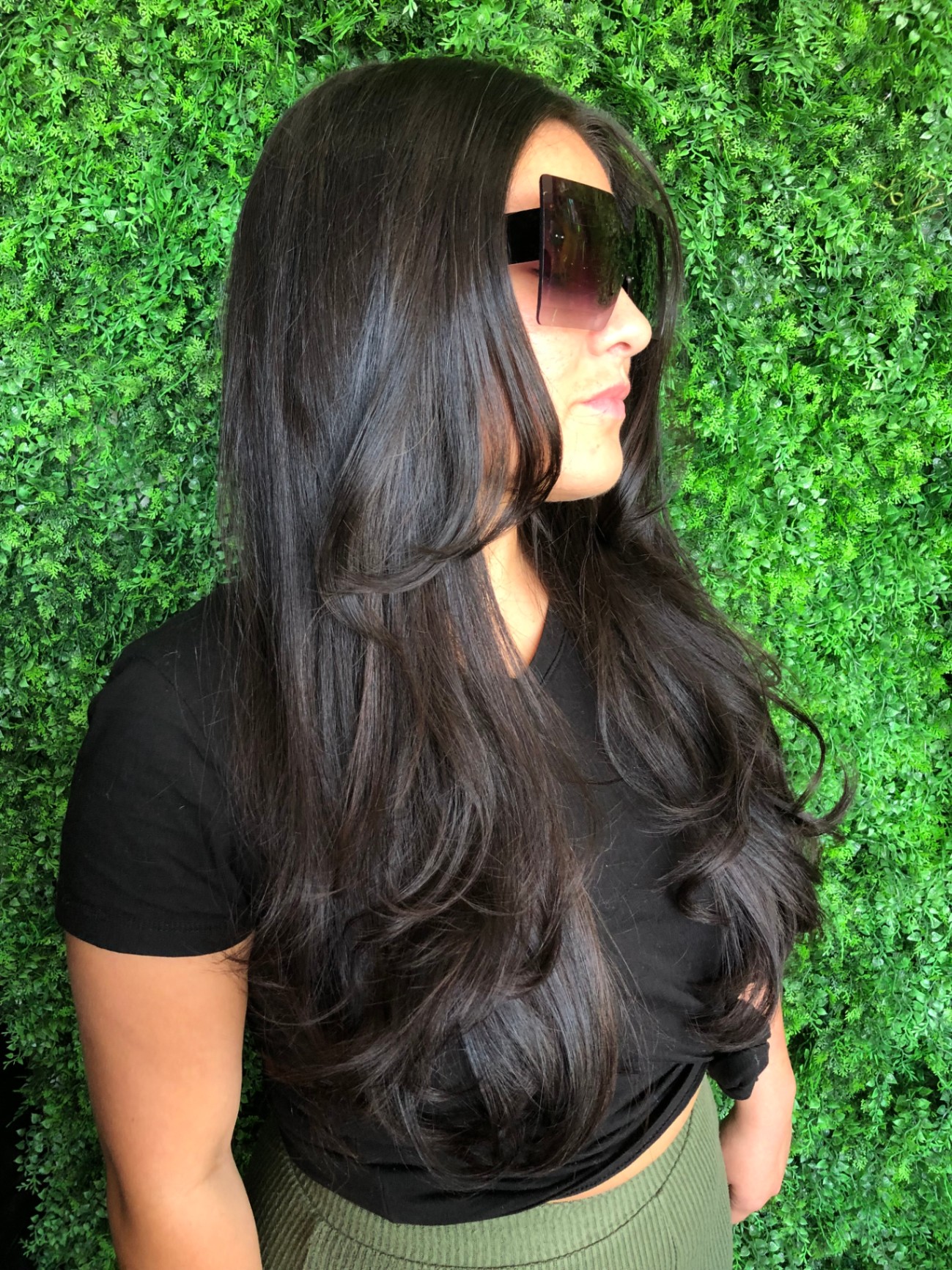 Brunette Model Against Green Plant Wall