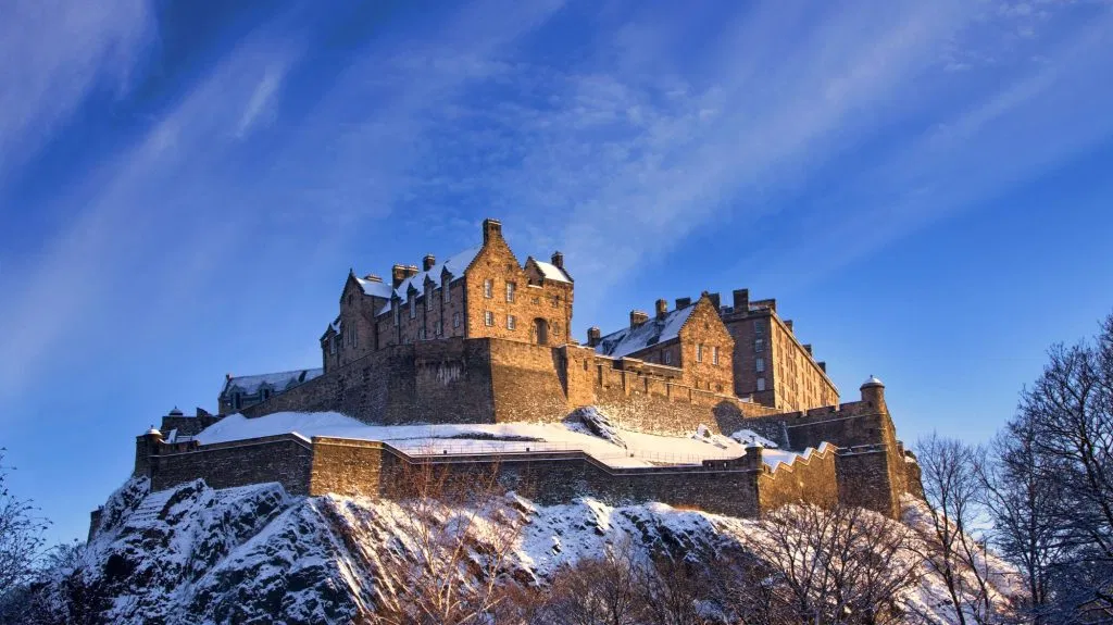 Edinburgh Castle in the winter snow under a clear blue sky