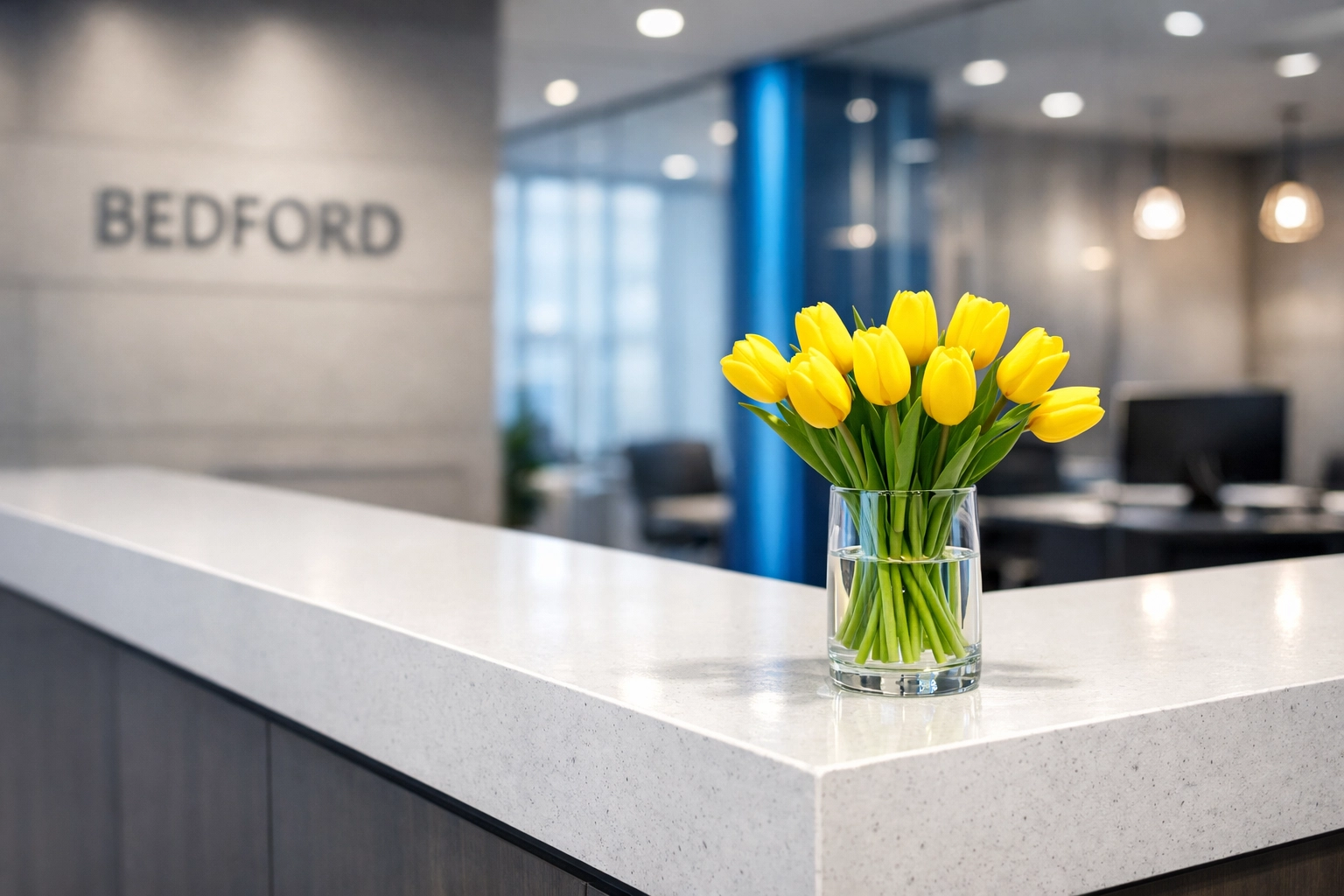 Spotless quartz reception desk in a modern Bedford office, highlighting the impact of regular office cleaning.