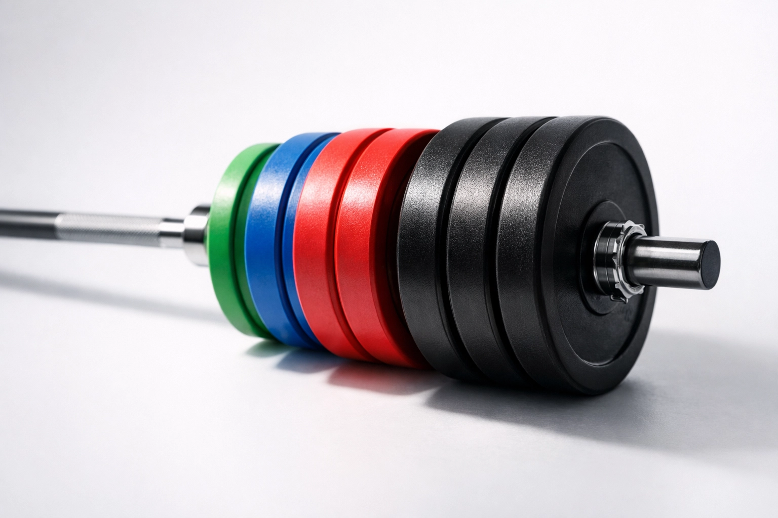 Barbell loaded with progressive weight plates showing gradual strength training increase