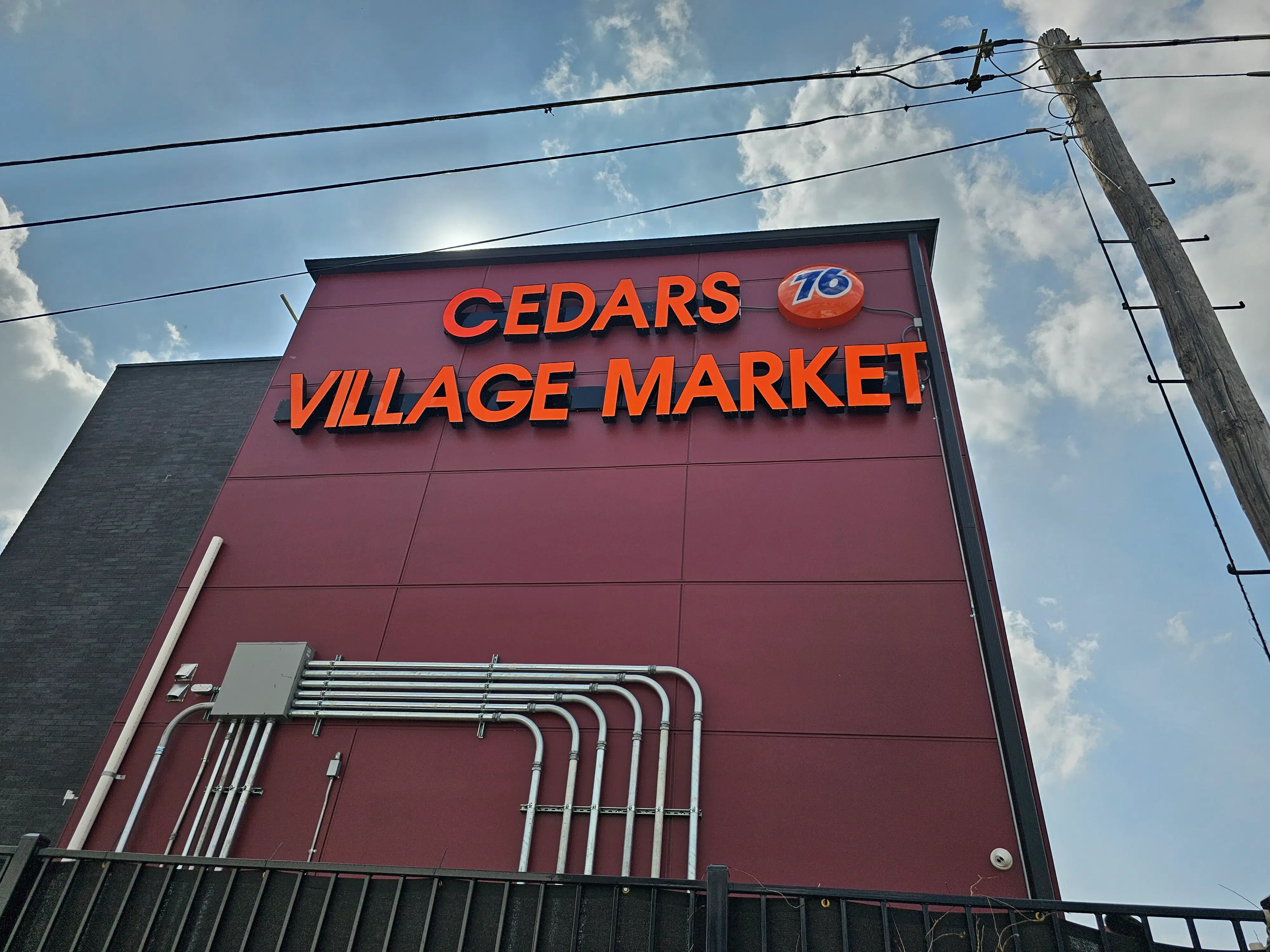 illuminated-storefront-sign-cedars-village-market-76-gas-logo.webp