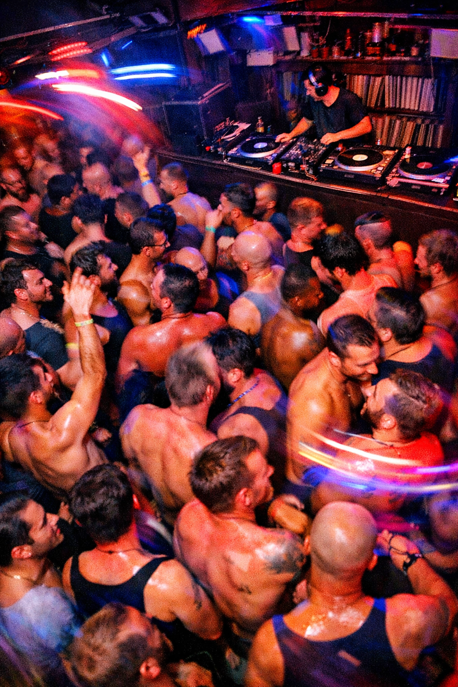 Gay men dancing on crowded bar dance floor celebrating community together