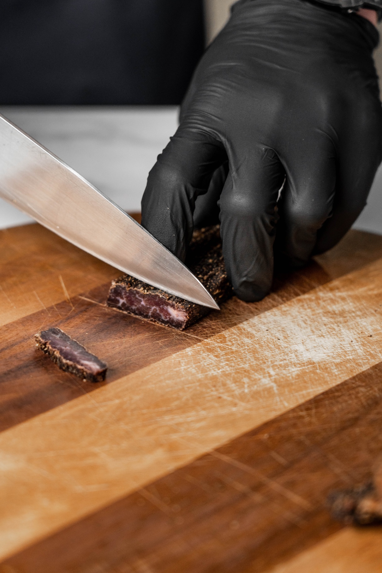 Biltong being sliced on board, high protein snacks, biltong recipes prep