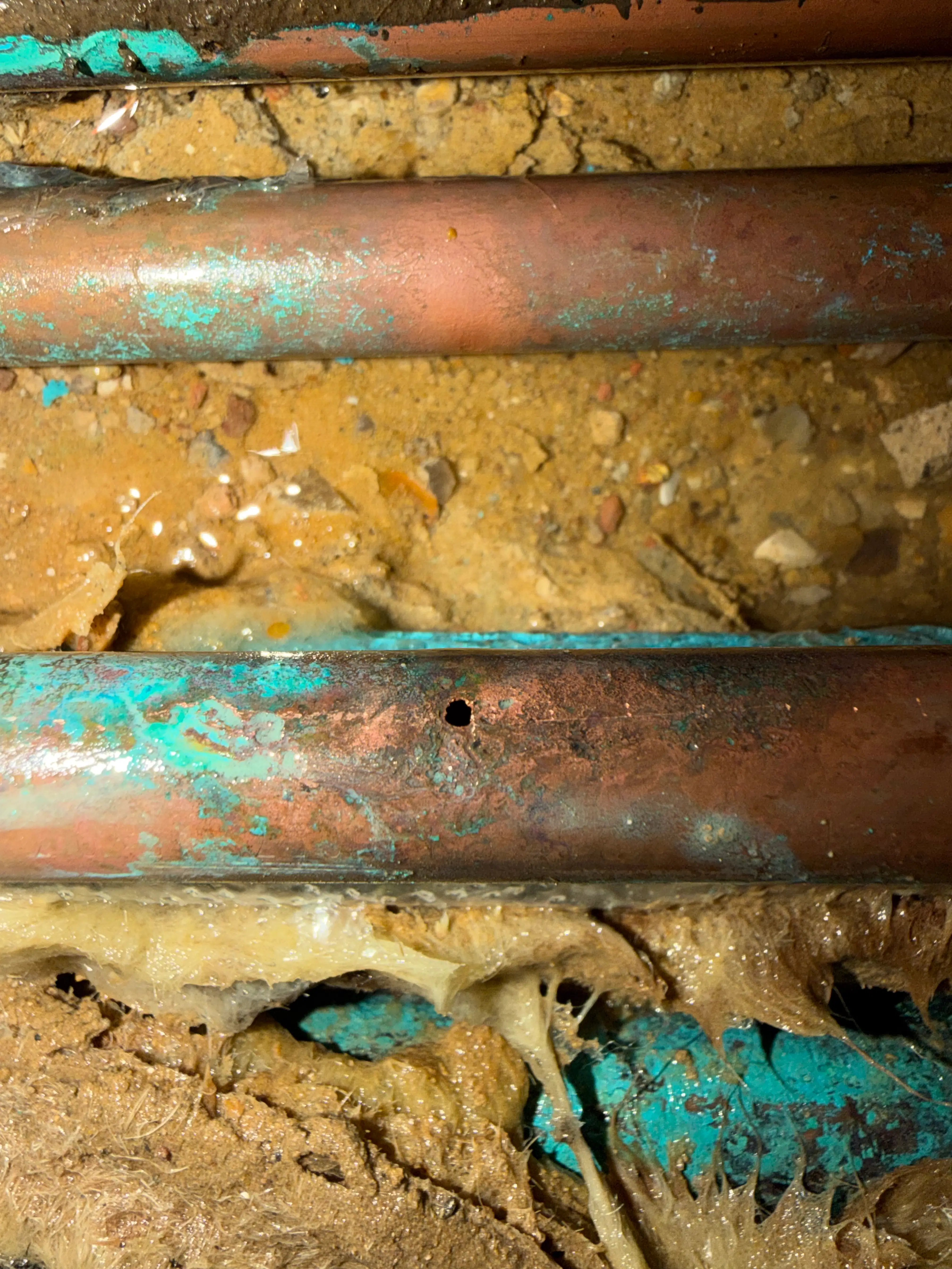 Real Aldershot job photo: corroded copper pipe with green oxidation (verdigris) and a pinhole leak