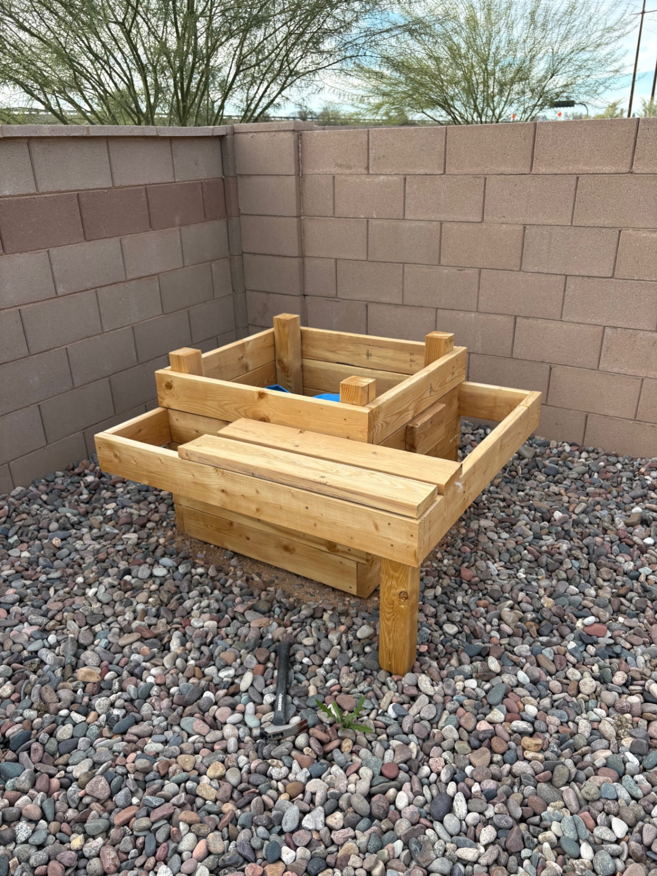 Custom-built wooden planter box A robust wooden planter box set in a desert landscape backyard