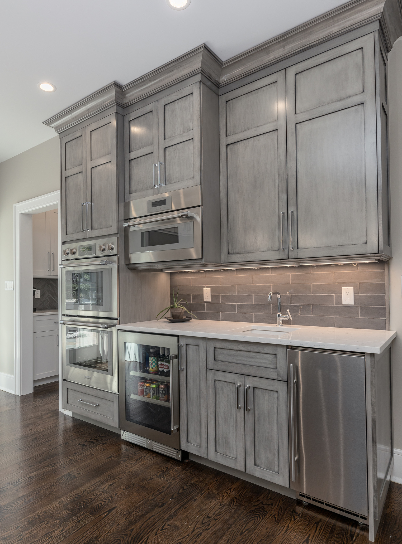 Custom kitchen design with gray-stained full-overlay custom cabinets, designed by a kitchen designer for a kitchen remodel design.