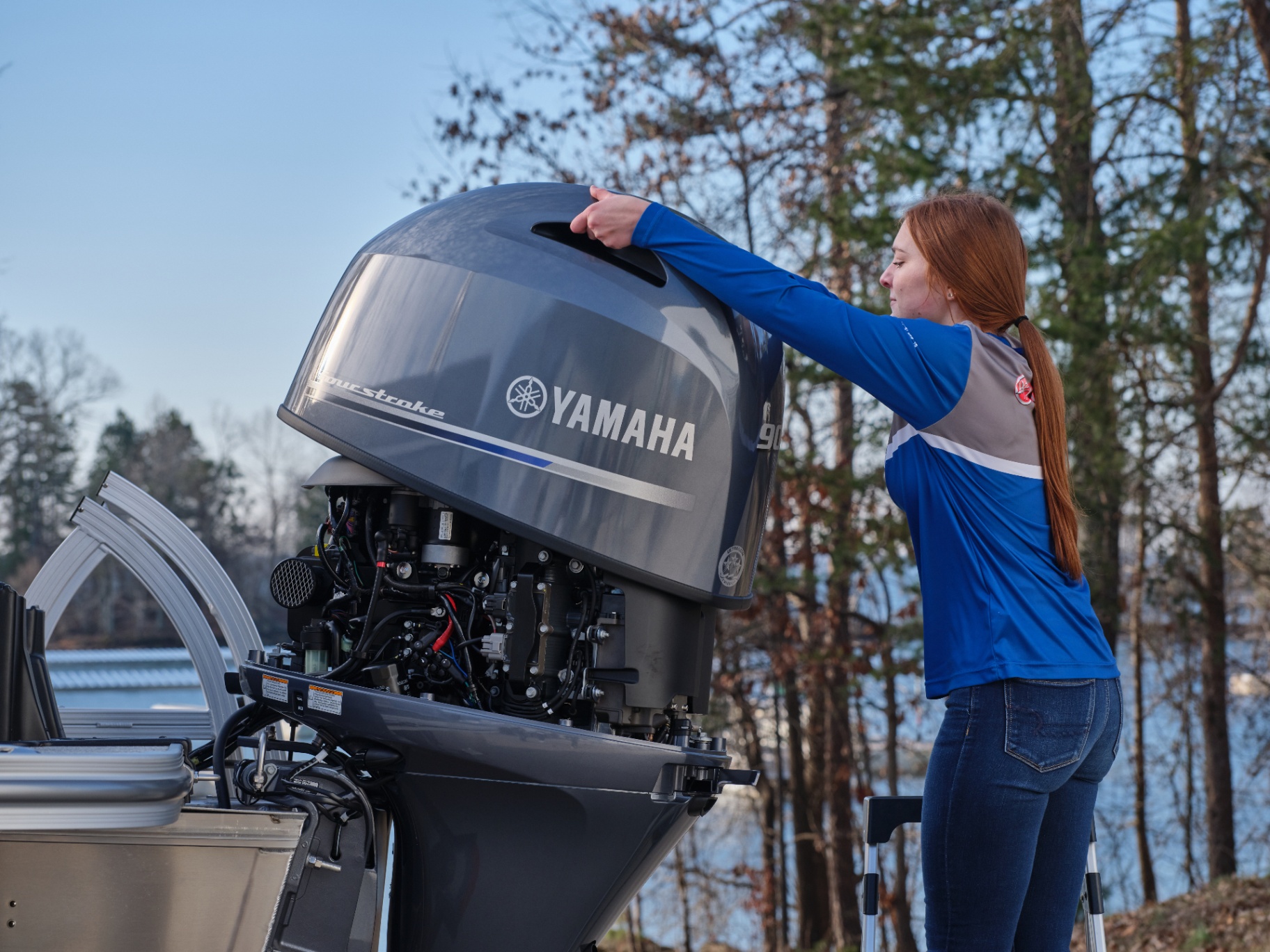 Technician performing maintenance on a Yamaha outboard motor on a pontoon boat