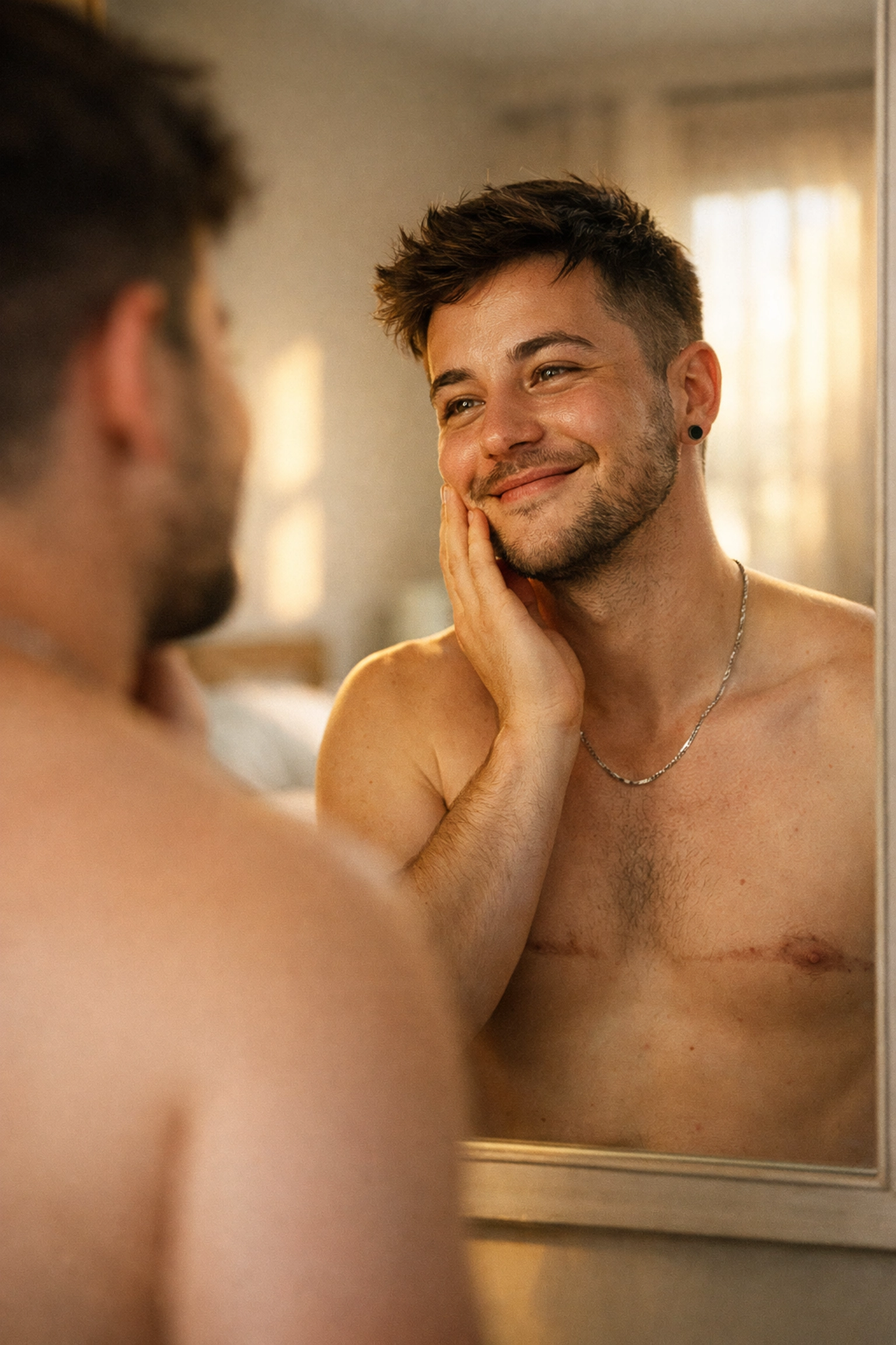 Trans man smiling at his reflection, showing gender euphoria and authentic LGBTQ+ lived experience.
