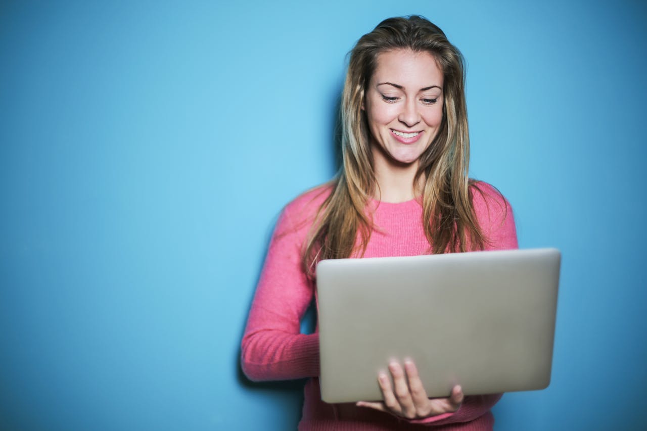 Premier Broadband residential fiber internet A woman uses a laptop with a smile, demonstrating reliable high-speed internet connectivity