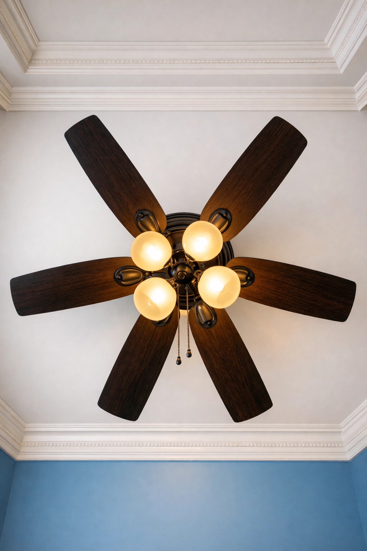 A professionally cleaned designer ceiling fan with light fixtures in a modern, luxury home.