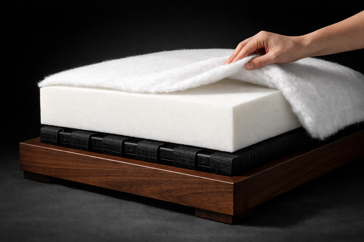 Internal layers of a furniture seat showing frame, webbing, high-resiliency foam, and dacron wrap.