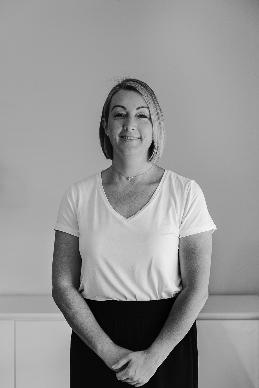 A woman stands in a bright, minimalist setting