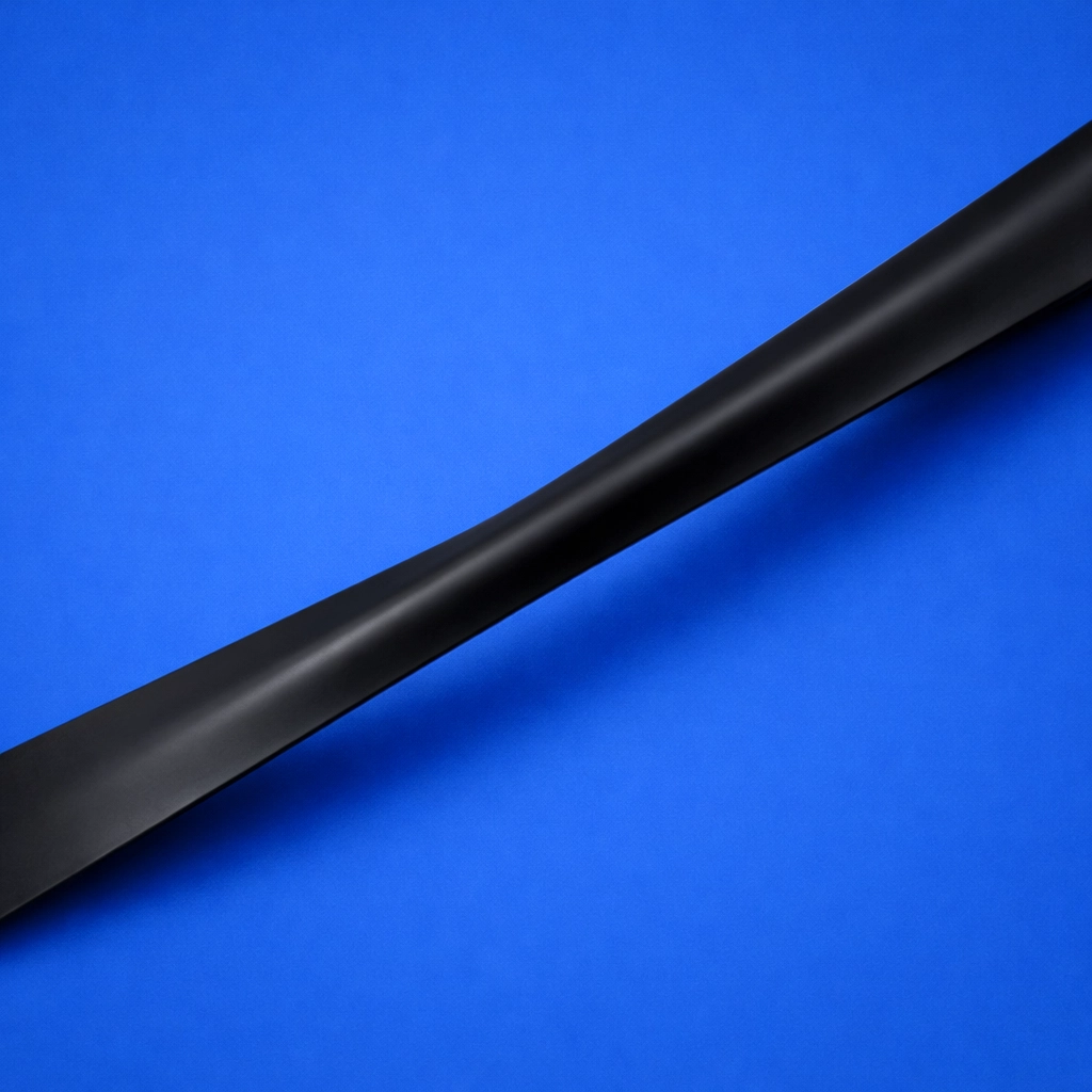 High-tension matte black resistance band stretched to demonstrate muscle growth and tension.