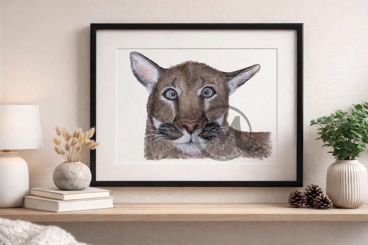 Framed Mountain Lion Majesty watercolor puma print on a shelf with a plant from the Monthly Animal Print Club